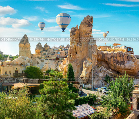 Hot air balloons at day in Goreme village, Cappadocia, Turkey. Day in Goreme village. Стоковое фото, агентство Ingram Publishing / Фотобанк Лори