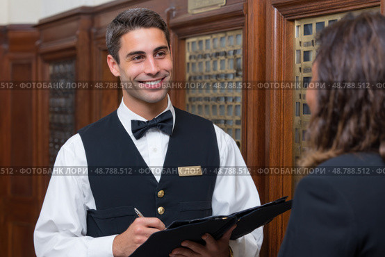Hotel concierge assisting a guest in lobby. Стоковое AI-изображение, AI-художник Юрий Поздников / Фотобанк Лори