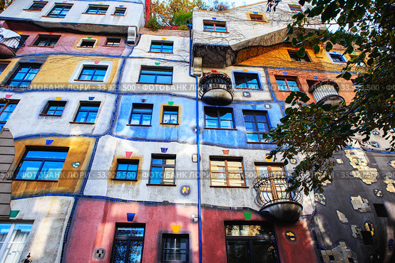 Hundertwasser house in Vienna, Austria. The Hundertwasserhaus apartment block has colorful facade, undulating floors, a roof covered with earth and grass, and large trees growing from inside (2019 год). Стоковое фото, фотограф Nataliia Zhekova / Фотобанк Лори