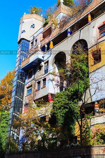 Hundertwasser house in Vienna, Austria. The Hundertwasserhaus apartment block has colorful facade, undulating floors, a roof covered with earth and grass, and large trees growing from inside (2019 год). Стоковое фото, фотограф Nataliia Zhekova / Фотобанк Лори