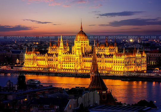Hungarian parliament on riverbank of Danube illuminated in evening, Budapest. Стоковое фото, агентство Ingram Publishing / Фотобанк Лори