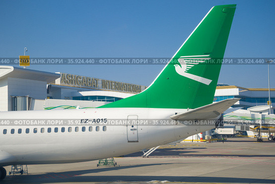 Хвостовая часть самолета BOEING 737-800 (EZ-A015) Туркменских авиалиний на фоне международного терминала Ашхабадского аэропорта. Туркменистан (2017 год). Редакционное фото, фотограф Виктор Карасев / Фотобанк Лори