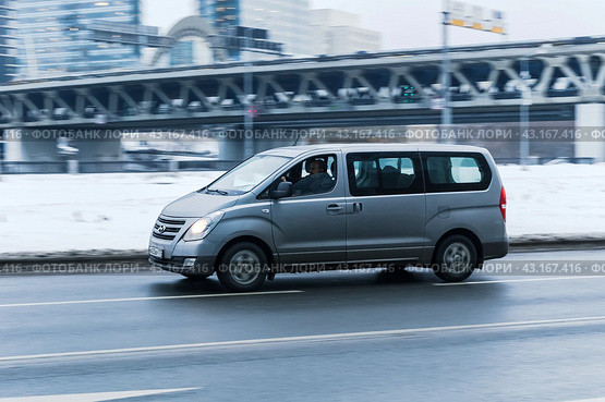 Hyundai H-1 in the city street in motion. Side view of gray color large Hyundai Grand Starex MPV minivan on winter road. Редакционное фото, фотограф Константин Григорьев / Фотобанк Лори
