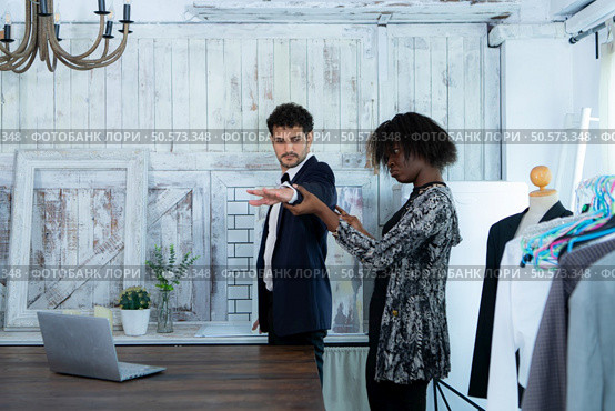 In a modern clothes fashion room, a clothing designer or tailor allows buyers to try on molded outfits before sewing them. Стоковое фото, агентство Ingram Publishing / Фотобанк Лори