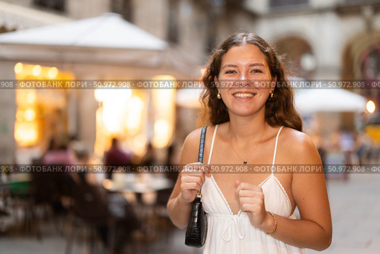 In evening, young smiling girl walks along city street Placa Real. Стоковое фото, фотограф Яков Филимонов / Фотобанк Лори