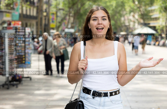 In pedestrian zone of historic European city stand suprised female tourist girl. Стоковое фото, фотограф Яков Филимонов / Фотобанк Лори
