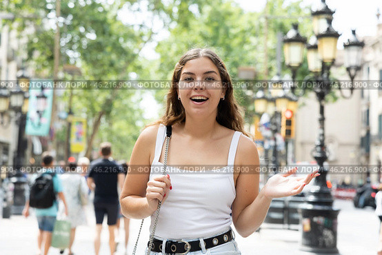 In pedestrian zone of historic European city stand suprised female tourist girl. Стоковое фото, фотограф Яков Филимонов / Фотобанк Лори