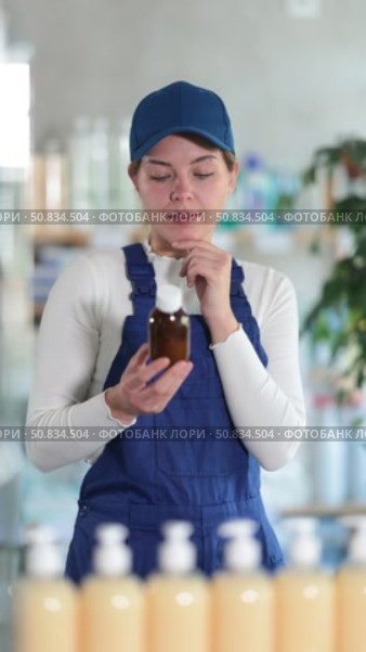 In sales area of pharmacy, builder woman examines packaging of expectorant syrup. Стоковое видео, видеограф Яков Филимонов / Фотобанк Лори