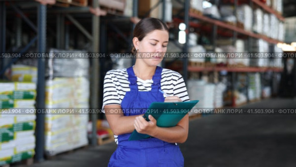 In warehouse of store, girl checks quantity of goods and receipt documents for products. Стоковое видео, видеограф Яков Филимонов / Фотобанк Лори
