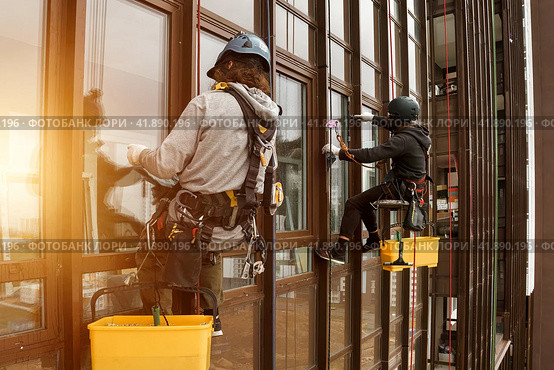 Industrial mountaineering workers hangs over residential facade building. Стоковое фото, фотограф Aleksandr Golubev / Фотобанк Лори