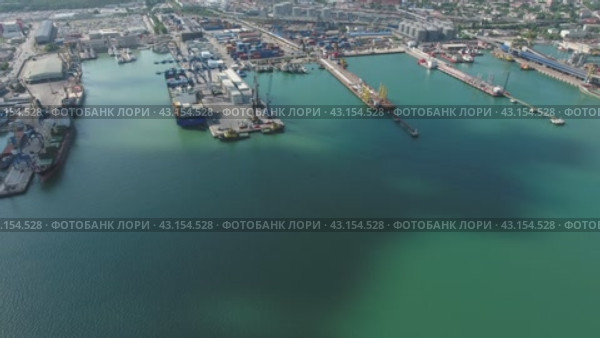 Industrial seaport, top view. Port cranes and cargo ships and barges. Loading and shipment of cargo at the port. View of the sea cargo port with a bird's eye view. Стоковое видео, видеограф Леонид Еремейчук / Фотобанк Лори