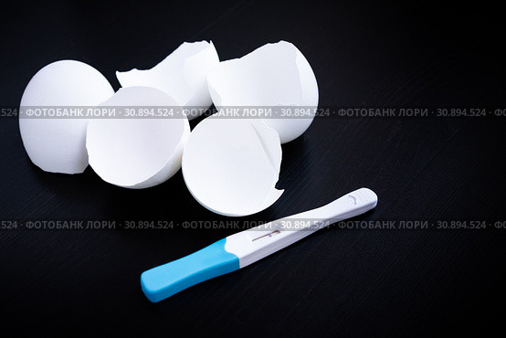 Infertility. Negative pregnancy test and eggshell on black. Стоковое фото, фотограф Papoyan Irina / Фотобанк Лори