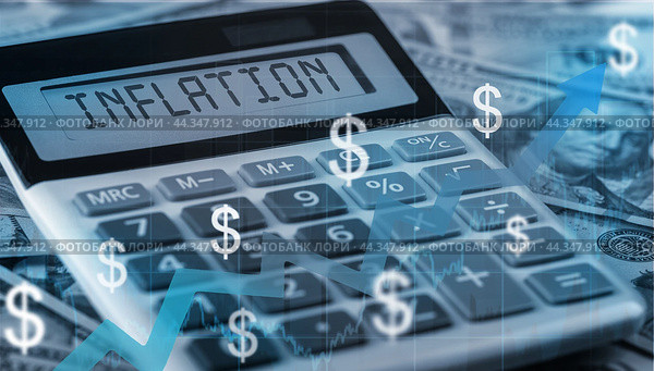 Inflation text on calculator on us dollars background. calculation of price increases, the cost of products and goods. US dollar inflation. Стоковое фото, фотограф Павел Муравьев / Фотобанк Лори