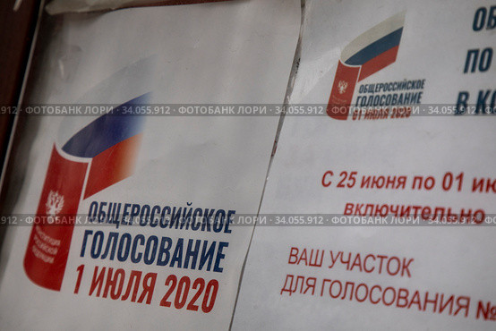 Информационный плакат с информацией о проведении Общероссийского голосования по поправкам в Конституцию Российской Федерации 1 июля 2020 висит у подъезда жилого дома в центре города Москвы, Россия. Редакционное фото, фотограф Николай Винокуров / Фотобанк Лори