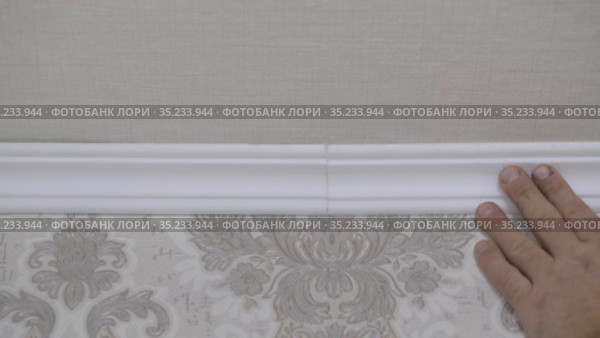 Installation of a ceiling skirting board on liquid nails to a ceiling, a wall. Стоковое видео, видеограф Константин Мерцалов / Фотобанк Лори