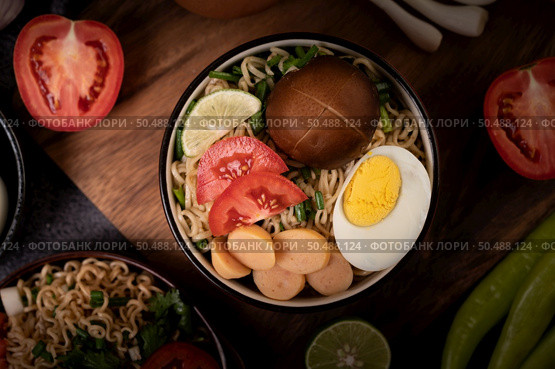 Instant noodles with minced pork, lime, onion, green peas, golden needle mushroom, and baby corn. Стоковое фото, агентство Ingram Publishing / Фотобанк Лори