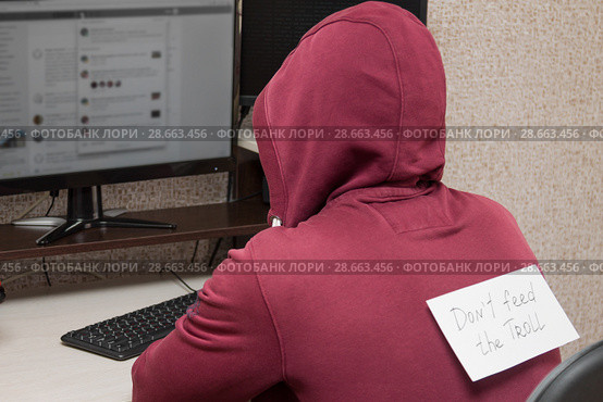 Интернет тролль у компьютера. Мужчина с надписью на спине : "Don't feed the troll" (Не кормите тролля) Стоковое фото, фотограф Лариса Капусткина / Фотобанк Лори