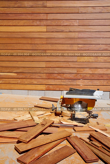 Ipe wood fence installation with carpenter table circular saw and sawdust. Стоковое фото, агентство Ingram Publishing / Фотобанк Лори