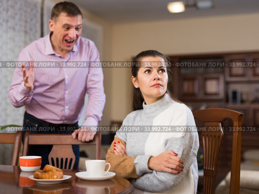 Irritated young spouses quarrelling in home interio. Стоковое фото, фотограф Яков Филимонов / Фотобанк Лори