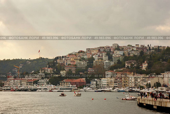 Istanbul, Turkey - December 11, 2017: Beautiful panoramic view of Istanbul from the sea to the coastal line with boats, ancient buildings, streets with people. Istanbul, Turkey - December 11, 2017: Beautiful panoramic view of Ferries in the Bosphorus, Редакционное фото, агентство Ingram Publishing / Фотобанк Лори