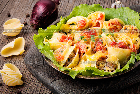 Italian foods concept.Italian style stuffed pasta shells with meat.Stuffed ricotta cheese shells.. Pasta stuffed with meat. Стоковое фото, агентство Ingram Publishing / Фотобанк Лори
