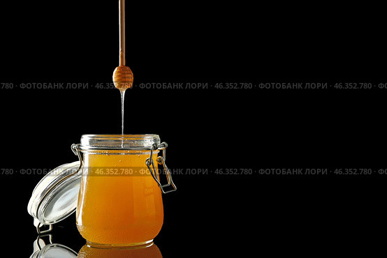 Jar and dipper with tasty honey on dark background. Стоковое фото, фотограф Pixel_shot / Фотобанк Лори