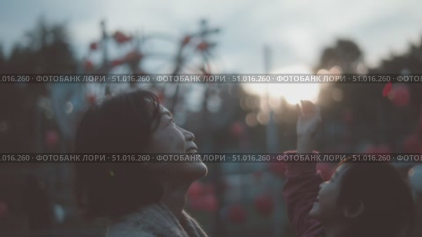 Joyful moments of a mother and child playing with a balloon during sunset in a festive park. Стоковое AI-видео, аниматор Сергей Толмачёв / Фотобанк Лори