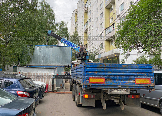 КамАЗ-65117 устанавливает бытовку во дворе жилого дома на время проведения ремонтных работ (2021 год). Редакционное фото, фотограф Мария Кылосова / Фотобанк Лори
