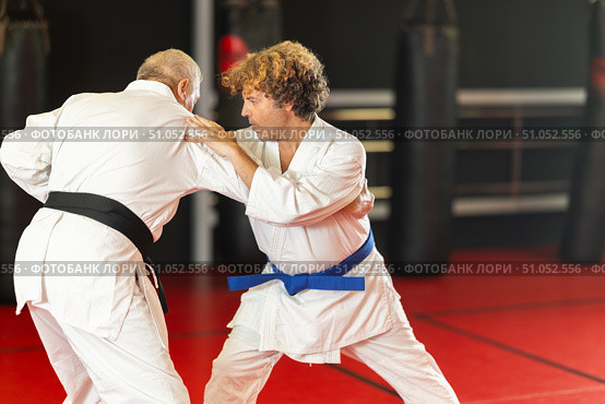 Karate with male athletes practicing, training and sparring in fight class. Стоковое фото, фотограф Яков Филимонов / Фотобанк Лори
