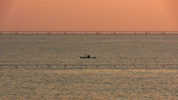 Каяк, плывущий в море на рассвете. Стоковое видео, видеограф Discovod / Фотобанк Лори