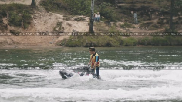 KAZAN, RUSSIA - June 12, 2023 - teenager confidently rides a gyro scooter and creates circles on the water. Редакционное видео, видеограф Strunov David / Фотобанк Лори