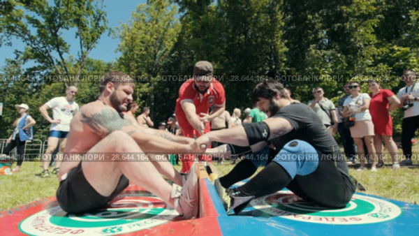 KAZAN, RUSSIA - JUNE 23, 2018: Traditional Tatar festival Sabantuy - Strong muscular men in battle of pulling the stick outdoors. Редакционное видео, видеограф Константин Шишкин / Фотобанк Лори