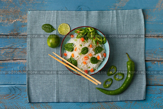 Композиция с миской вкусной рисовой лапши, перцем чили и лаймом на цветном деревянном фоне. Стоковое фото, фотограф Pixel_shot / Фотобанк Лори