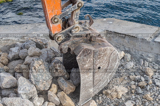 Ковш экскаватора загружает крупные камни. Excavator bucket filled with stones and pieces of concrete. Стоковое фото, фотограф Татьяна Д / Фотобанк Лори