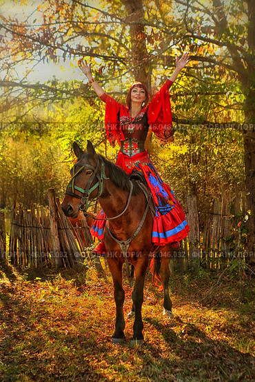 Красивая женщина в цыганском наряде сидит на рыжем коне. Стоковое фото, фотограф Марина Володько / Фотобанк Лори