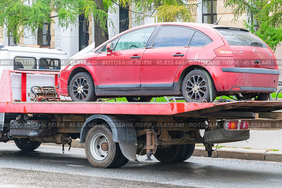 Красный автомобиль загружен на эвакуатор. Эвакуация автомобилей нарушающих правила парковки. Редакционное фото, фотограф Антон Вахрушев / Фотобанк Лори