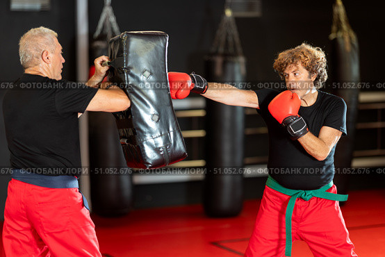 Krav Maga student punching shield during self‑defense drill. Стоковое фото, фотограф Яков Филимонов / Фотобанк Лори