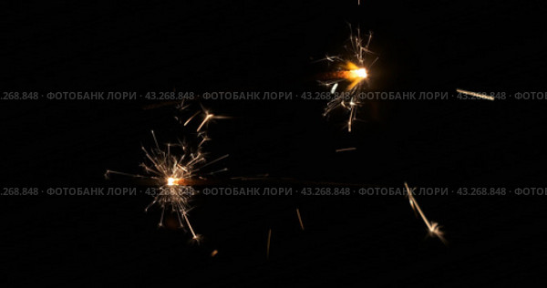 Крупный план бенгальских огней, горящих и искрящихся в темноте. Две бенгальские палочки горят, отдаляясь друг от друга.. Close-up of sparklers burning and sparking in the dark. Стоковое видео, видеограф Александр Собко / Фотобанк Лори