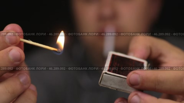 Крупный план: мужчина поджигает деревянную спичку. Сосредоточьтесь на спичке. Деревянная спичка в руке. Стоковое видео, видеограф Александр Собко / Фотобанк Лори