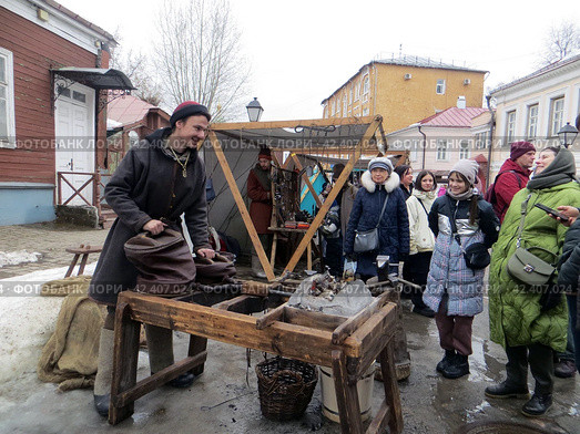 Крутицкое патриаршее подворье.Празднование традиционного русского зимнего праздника Масленица.Ярмарочная площадь.Кузнец раздувает меха и рассказывает зрителям истории.Москва. Россия. (2024 год). Редакционное фото, фотограф Мария Фетисова / Фотобанк Лори