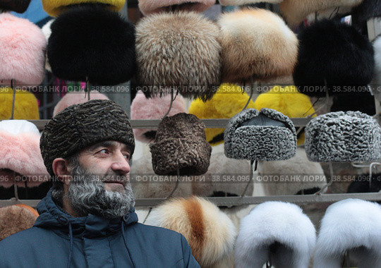 Курбан из Дагестана продаёт головные уборы на Измайловском Вернисаже (2022 год). Редакционное фото, фотограф Дмитрий Неумоин / Фотобанк Лори