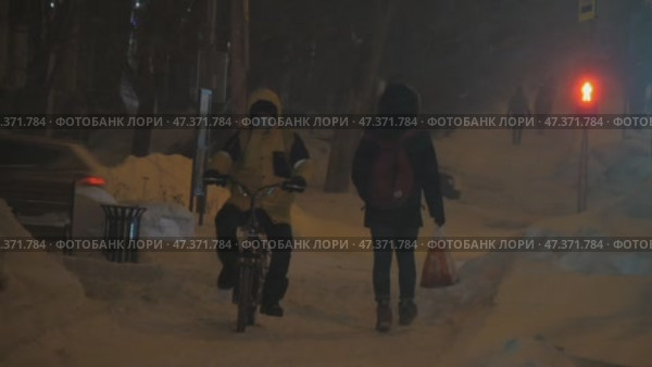 Курьер Яндекс Еды едет по заснеженной дороге ночью. Редакционное видео, видеограф Семён Прудий / Фотобанк Лори