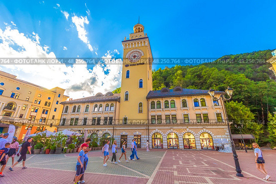 Курорт Роза Хутор, Краснодарский край. Здание Ратуши с видом на горы. Rosa Khutor, Krasnodar region, Russia - June 23, 2024: Town Hall or Ratusha in Rosa Khutor - largest mountain ski resort in Russia, near popular destinations Sochi, Adler. Редакционное фото, фотограф Елена Серебрякова / Фотобанк Лори