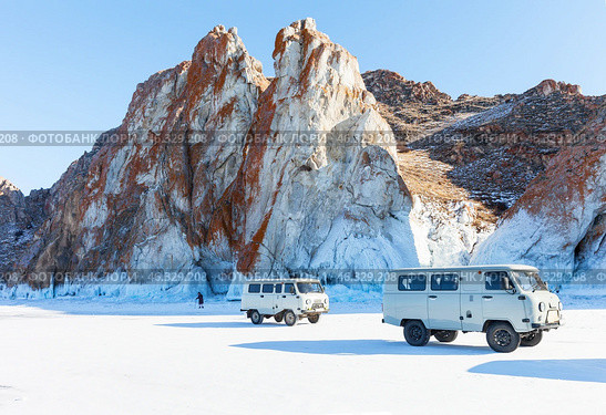 LAKE BAIKAL, OLKHON ISLAND, IRKUTSK REGION, RUSSIA -  February 22, 2025: Tourists arrived to famous rocks of Cape Sagan-Khushun in traditional UAZ off-road vehicle on sunny winter day. Редакционное фото, фотограф Виктория Катьянова / Фотобанк Лори