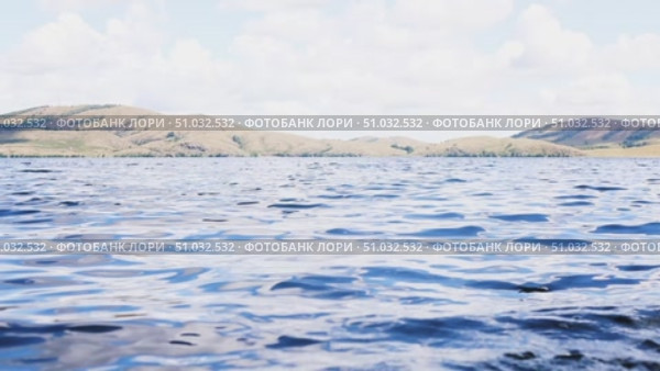 Lake Bannoe, Russian Federation - July 31, 2025: Serene lake view with gentle ripples reflecting clouds and distant hills under a bright blue sky, showcasing natural beauty and tranquility. Редакционное видео, видеограф Ирина Ручушкина / Фотобанк Лори