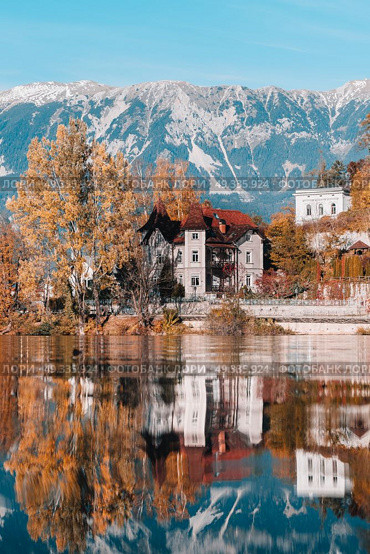 Lake Bled in the Alpine mountains in autumn under blue sky. Стоковое фото, агентство Ingram Publishing / Фотобанк Лори