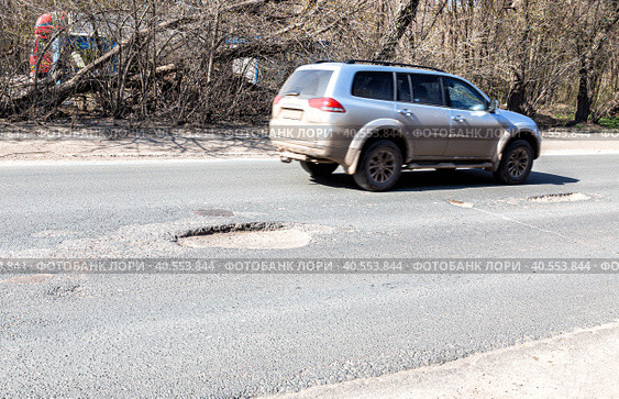 Large pothole an example of poor road maintenance. Стоковое фото, фотограф FotograFF / Фотобанк Лори