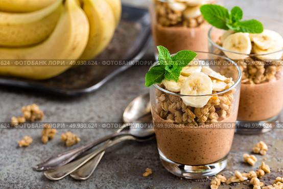 Layered chocolate chia pudding parfait with banana, granola and yogurt, dessert. Стоковое фото, агентство Ingram Publishing / Фотобанк Лори