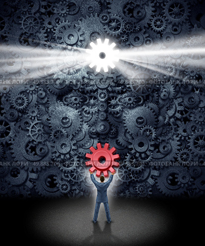 Leadership support concept as a businessman holding the missing key cog to a large corporation as a group of gears shaped as a human face as a symbol and metaphor for workers contributing new business ideas and innovative content. Стоковое фото, агентство Ingram Publishing / Фотобанк Лори