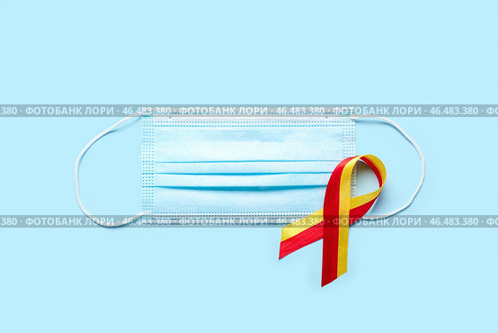 Лента осведомленности с медицинской маской на синем фоне. Концепция гепатита. Стоковое фото, фотограф Pixel_shot / Фотобанк Лори